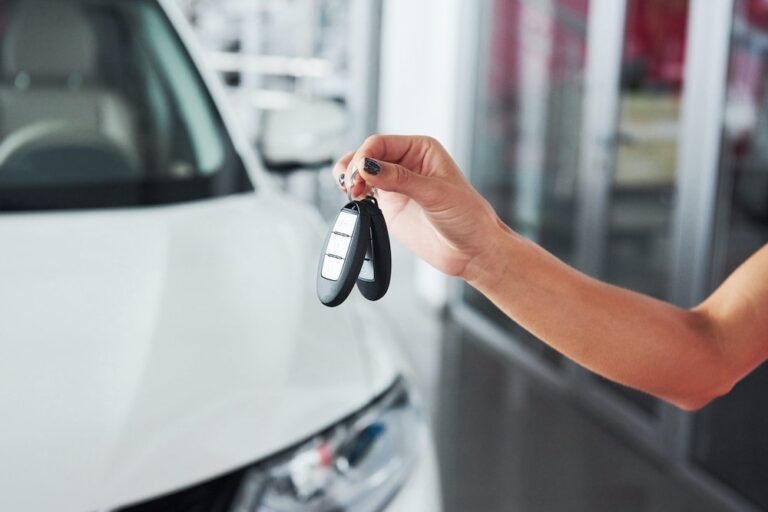 Person holding car keys to depict selling auto dealer reinsurance.